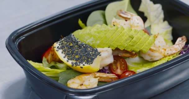Свежий салат с креветками и авокадо в коробке — стоковое видео