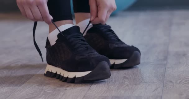 Активна жінка зав'язує шнурки перед спортивним тренуванням — стокове відео