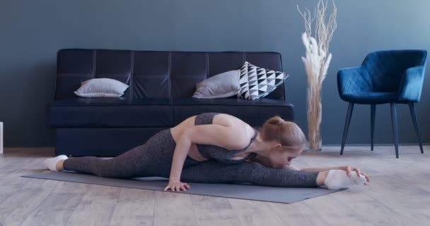 Graceful elastyczne dziewczyna siedzi w szpary i rozciągając swoje ciało — Wideo stockowe