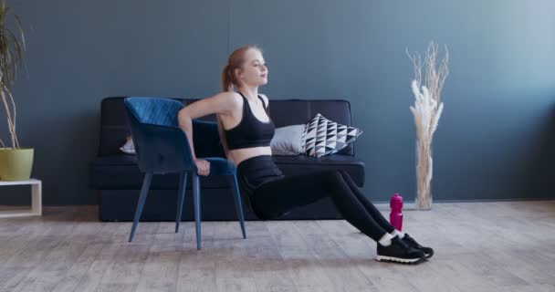 Fitness flicka huk lutar landar på stolen — Stockvideo