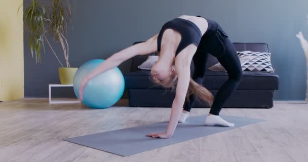 Junge Frau steht in Brückenpose und praktiziert Yoga — Stockvideo