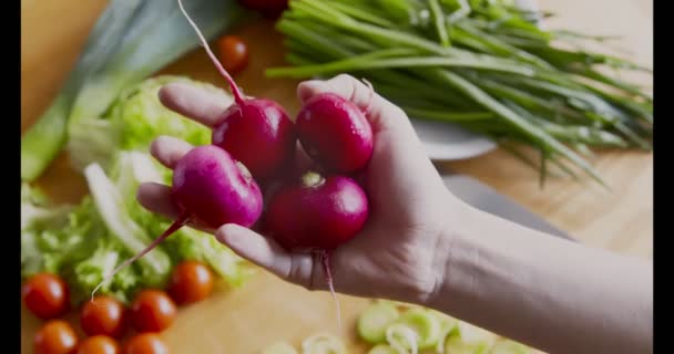 Frau hält Bündel frischen Bio-Rettich in der Küche — Stockvideo