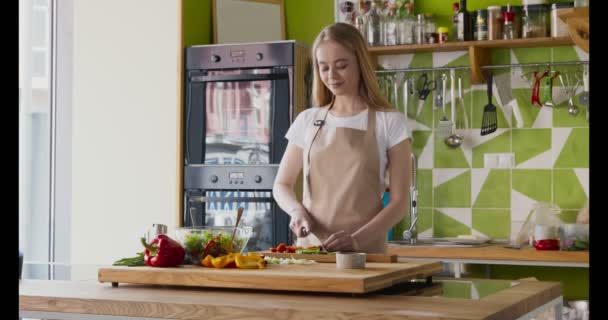 Jovem mulher cortando tomates frescos para salada de legumes — Vídeo de Stock