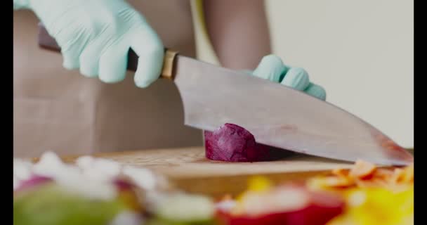 Gros plan des mains féminines dans les gants coupant la betterave — Video