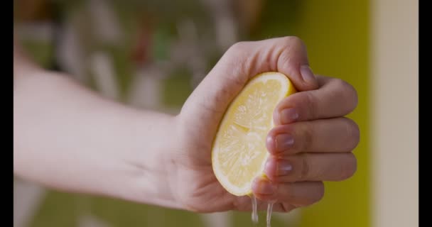 Mano femminile spremendo la metà di limone fresco, facendo il succo — Video Stock