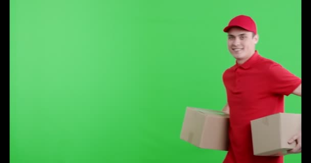 Cheerful delivery guy bringing two parcels for you — Stock Video