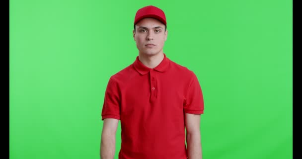 Entrega homem em uniforme vermelho gestual sinal de parada na câmera — Vídeo de Stock