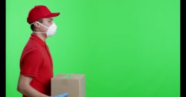 Koruyucu maskeli ve eldivenli kurye paket veriyor.