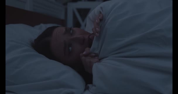 Gadis khawatir berbaring terjaga di tempat tidur, menutupi wajah dengan selimut — Stok Video