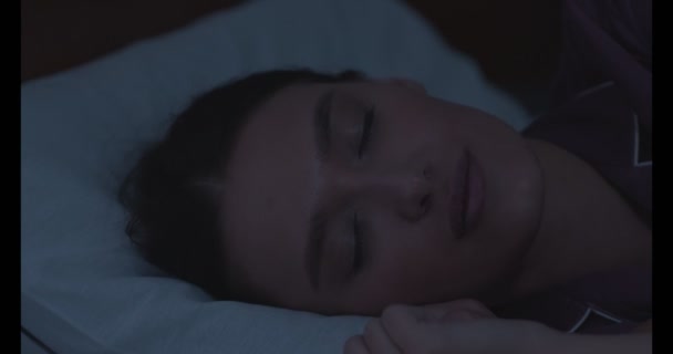 夜にベッドで寝る若い女性の肖像 — ストック動画