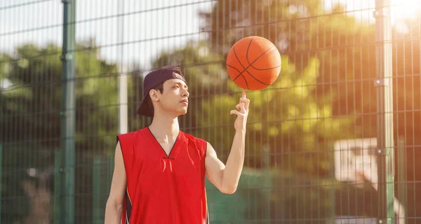 Olahragawan Asia dengan bola di luar lapangan basket, panorama — Stok Foto