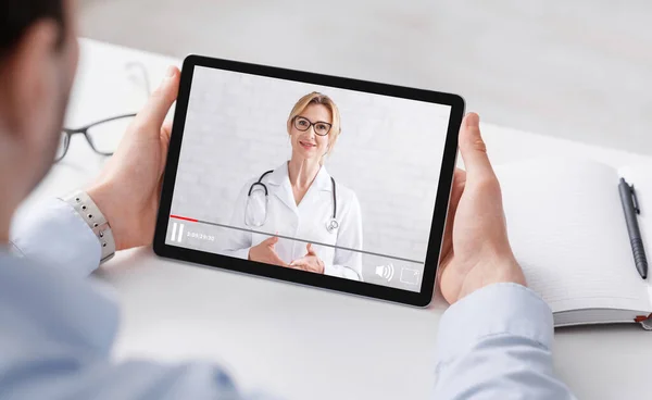 Blog sulla salute. Uomo in camicia guardando video medico con donna medico su tablet — Foto Stock