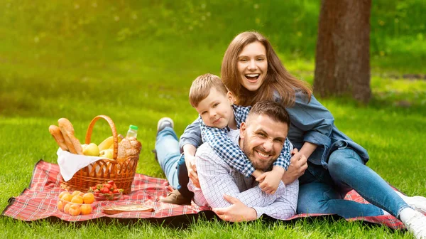 Familjeband. Söt pojke med mamma och pappa på sommaren picknick på landsbygden, tomt utrymme — Stockfoto