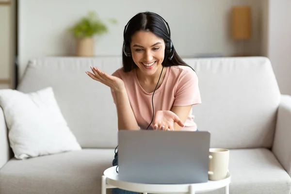 Gelukkig vrouw in headset het maken van video bellen zitten thuis — Stockfoto