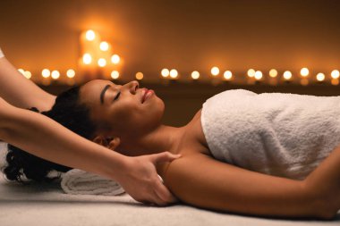 Kadın terapist elleri spa 'da Afrikalı kadınların omuzlarına masaj yapıyor.