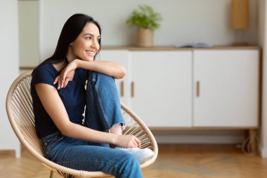 Samimi sandalyesinde oturan ve hafta sonunun keyfini çıkaran kadın.