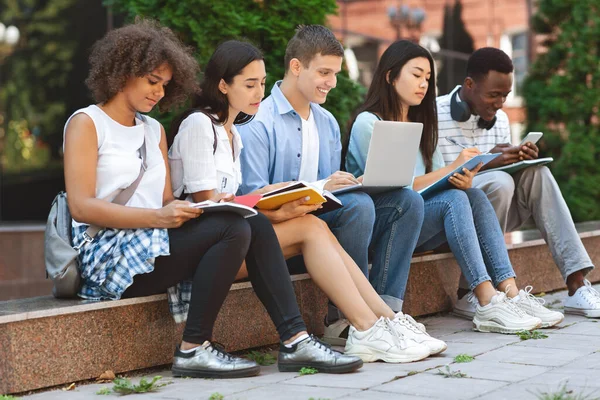 Skupina multietnických studentů studujících na nádvoří univerzity — Stock fotografie