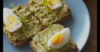 Avokado, yumurta ve mikro yeşillikli üç tost.