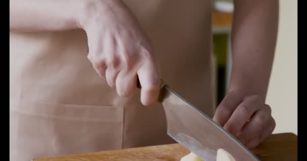 Woman chef cutting potatoes on kitchen board — Stock Video