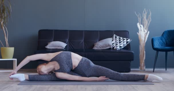 Flexibel kvinna utövar yoga, gör splits motion — Stockvideo