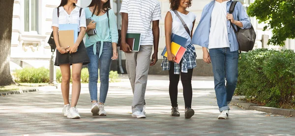 Glada tonårsstudenter lämnar college efter lektionerna, går tillsammans utomhus — Stockfoto