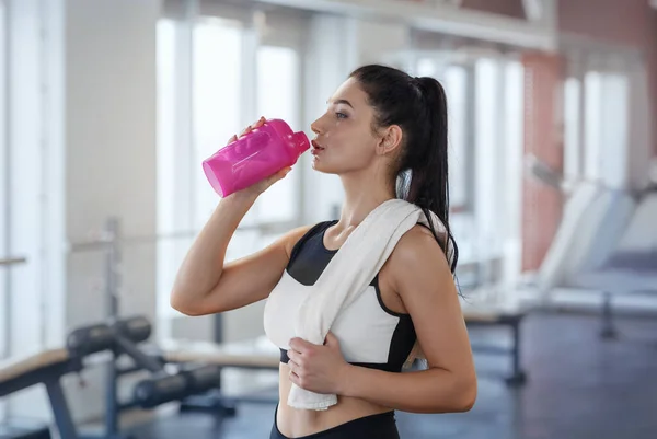 ผู้หญิงสาวนักกีฬาดื่มโปรตีนสั่นหลังจากการฝึกที่สปอร์ตคลับ — ภาพถ่ายสต็อก