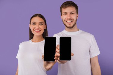 Kameraya boş cep telefonu ekranı gösteren mutlu çift