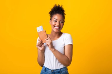 Bilet ve pasaport taşıyan heyecanlı afro kız