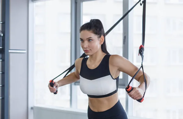 Starkes Mädchen trainiert mit Seilmaschine, stemmt Gewichte im Fitnessstudio — Stockfoto