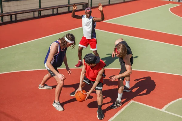 Pemuda multi etnis olahragawan bermain basket di taman bermain luar ruangan — Stok Foto