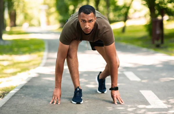 Retrato del atractivo velocista afroamericano listo para correr en el parque de la ciudad —  Fotos de Stock