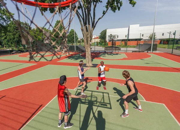 Di atas tampilan tim olahraga multirasial yang bermain basket di lapangan terbuka — Stok Foto