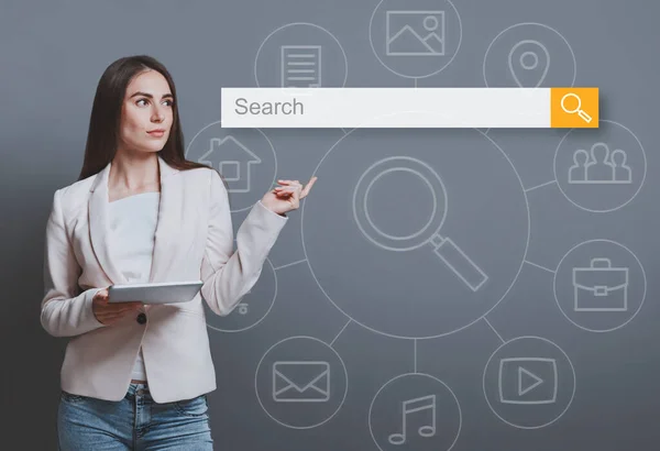 Femme d'affaires avec tablette pointant doigt à la barre de recherche, fond gris — Photo