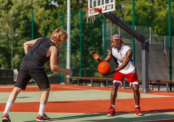 Dua olahragawan Millennial bermain basket di arena luar ruangan pada hari musim panas — Stok Foto