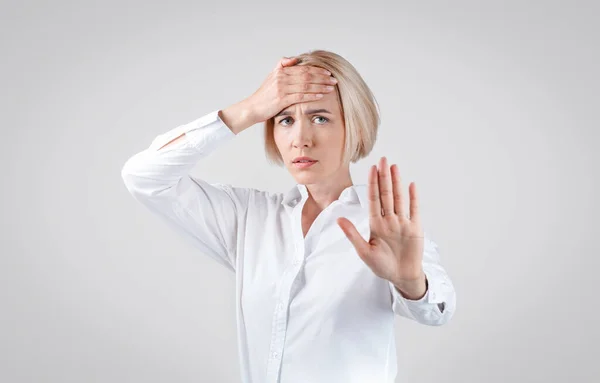 Blondynka bizneswoman pokazuje gest STOP na szarym tle — Zdjęcie stockowe