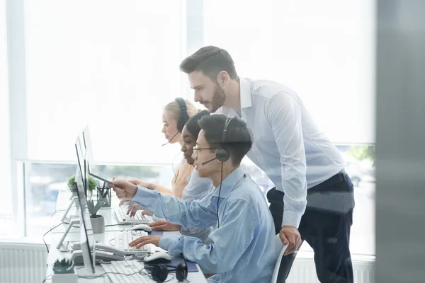 Treinador executivo de atendimento ao cliente auxiliando seu supervisor no escritório do call center — Fotografia de Stock