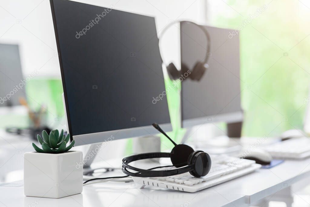 Call center and customer service. Computer monitor with blank space for your design and VOIP headset on desk in office