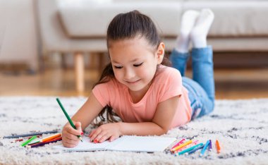 İçerde Yerde Yatan Renkli Kalemler Kullanarak Resim Çizen Kız