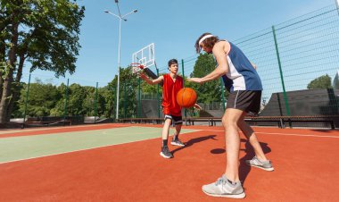İki profesyonel basketbolcunun panoramik görüntüsü açık sahada yarışmaya hazırlanıyor, boş alan