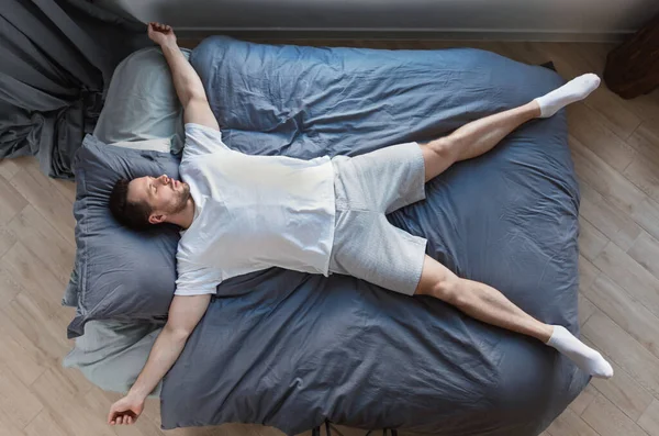 Man slapend liggend op terug in bed thuis, Top-View — Stockfoto