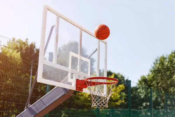 Bola basket melewati keranjang di luar arena olahraga, ruang kosong — Stok Foto