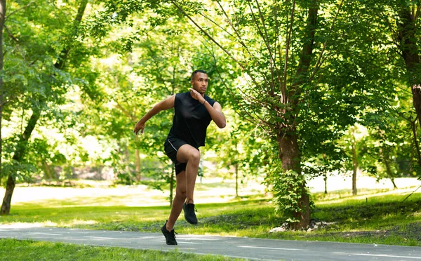 Handsome millennial sprinter running on track at beautiful park, copy space — Stock Photo, Image