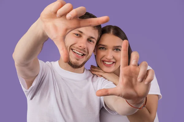 Belo jovem casal está fazendo quadro, olhando para a câmera — Fotografia de Stock