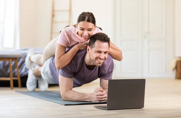 Pojkvännen gör Plank med flickvännen som ligger på honom hemma — Stockfoto