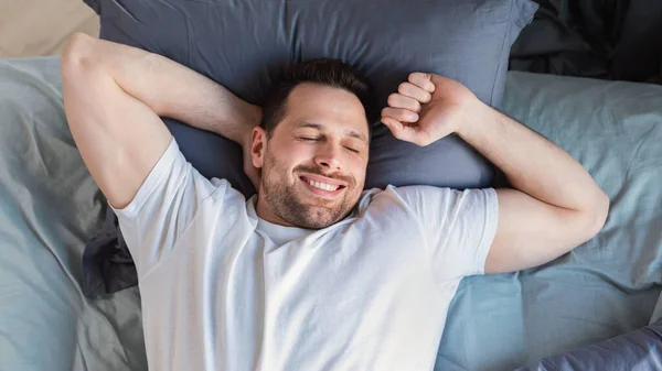 Chico feliz despertando acostado en la cama en casa, Top-View — Foto de Stock