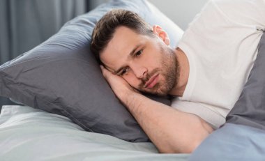 Depresyondaki adam uykusuzluk çekiyor. Evde yatakta yatıyor.