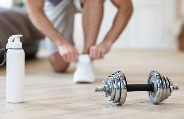 Guy Lacing Shoes Before Training At Home, Focus On Dumbbells — Stock Photo, Image