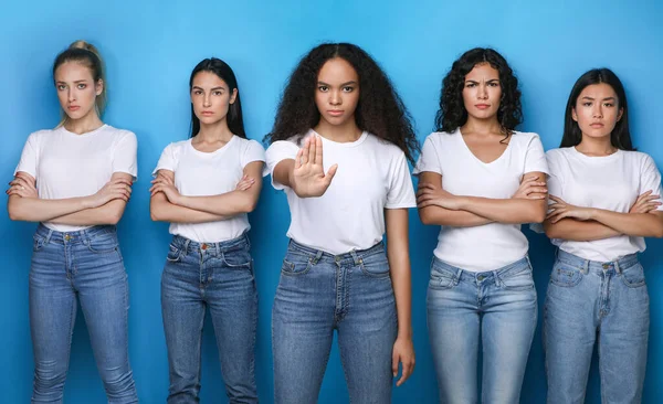 Gestikulierende multiethnische Frauen hören auf, missbilligend vor blauem Hintergrund zu posieren, Studio — Stockfoto