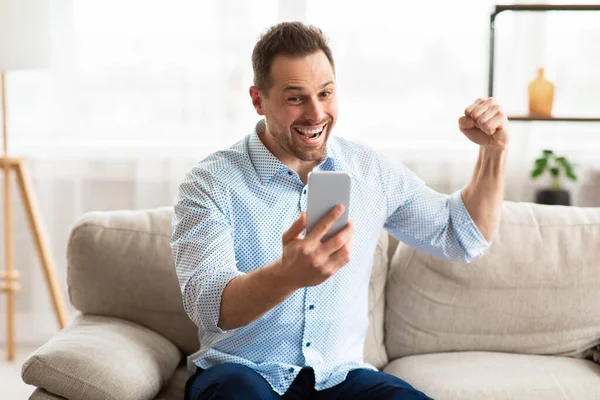 Guy celebrating victory online using cell phone — Stock Photo, Image