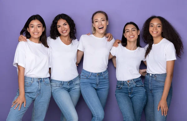 Diversas mujeres abrazando de pie sobre fondo púrpura, Studio Shot — Foto de Stock